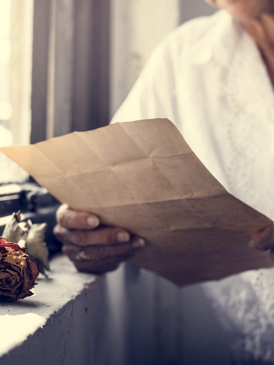 Elderly asian woman sitting thoughful with old letters in her hands