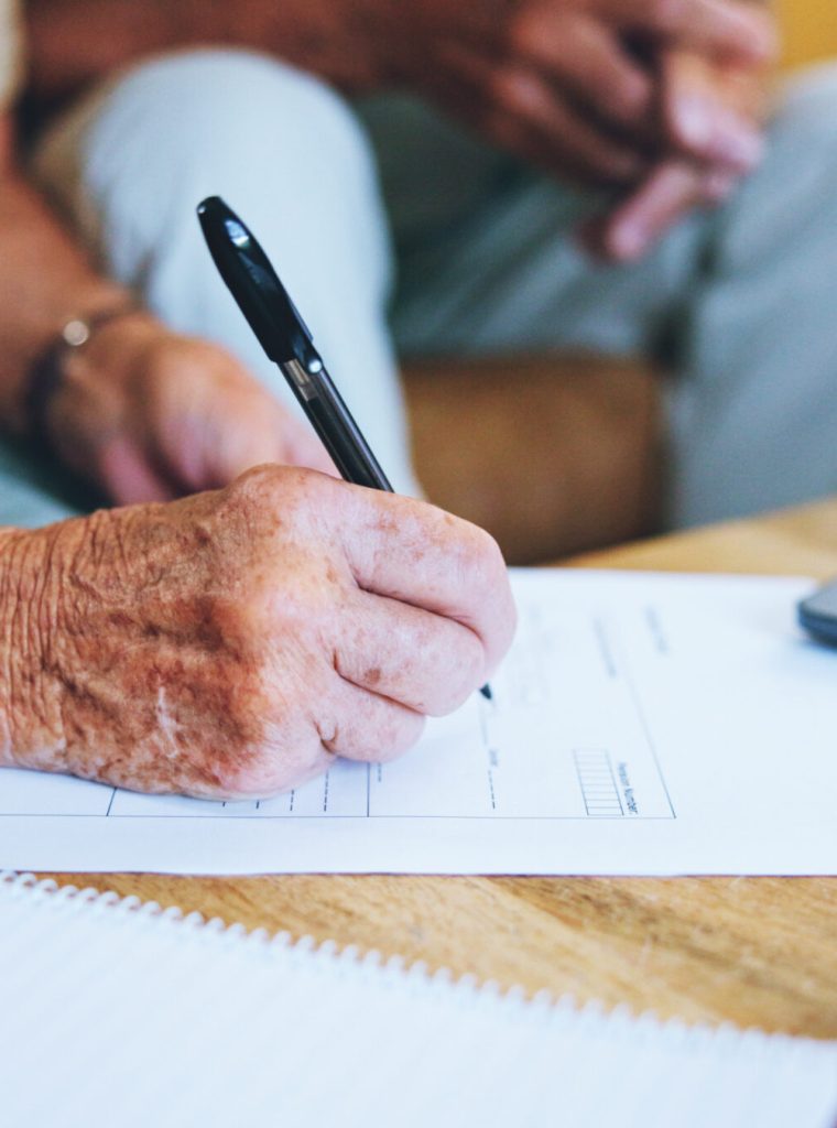 Senior man, paperwork and hands to sign or home for finance, life insurance and planning for assets.