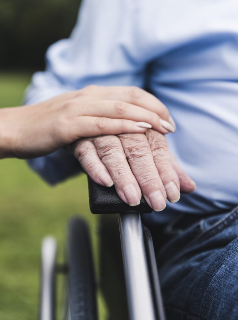 Young woman touching senior man's hand, close-up